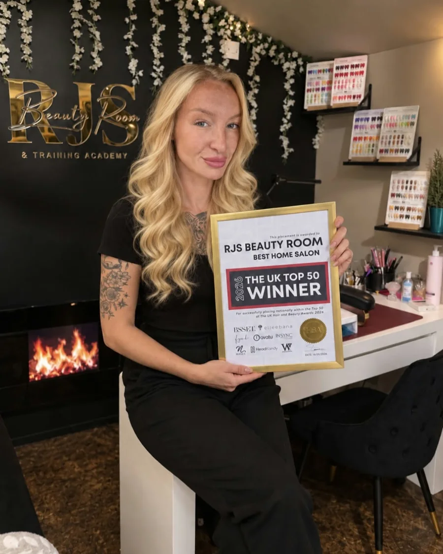 Ramone holding the RJS Beauty Room award certificate in her salon
